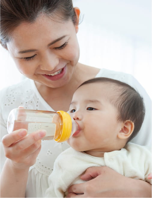 赤ちゃんにミルクをあげている女性